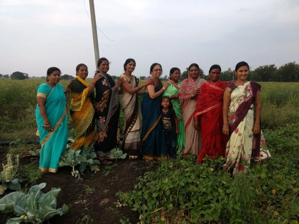 Prema with grassroots women in an outdoor SURE community setting